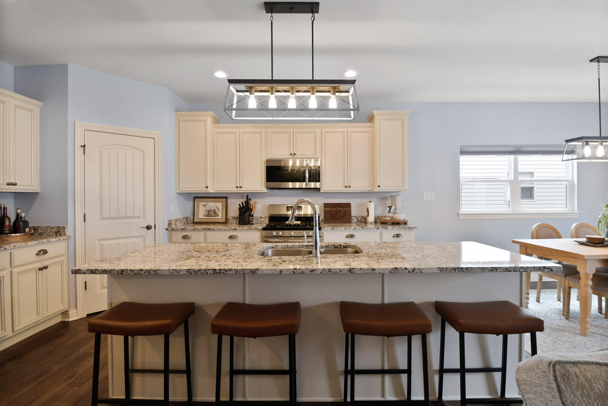 10188 Azalea Drive Crown Point, IN 46307 - Photo 3 of 29 a kitchen with granite countertop a table chairs stove and cabinets