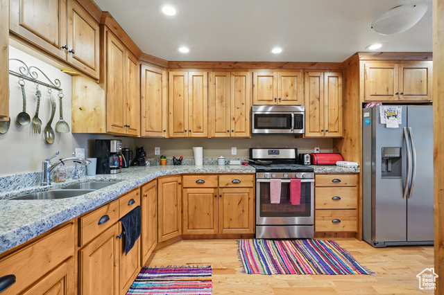 2490 South State Street Springville, UT 84663 - Photo 26 of 38 Kitchen with light wood-style flooring, light stone countertops, a sink, and appliances with stainless steel finishes