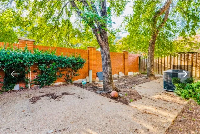 a view of a brick house with many windows next to a road