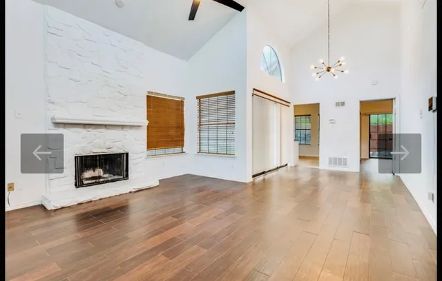 an empty room with windows and a fireplace