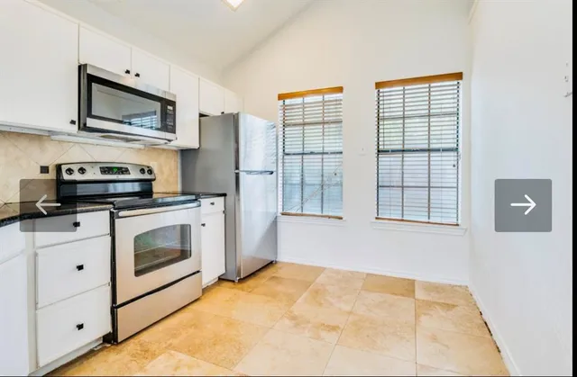 a kitchen with stainless steel appliances a stove a sink and a microwave