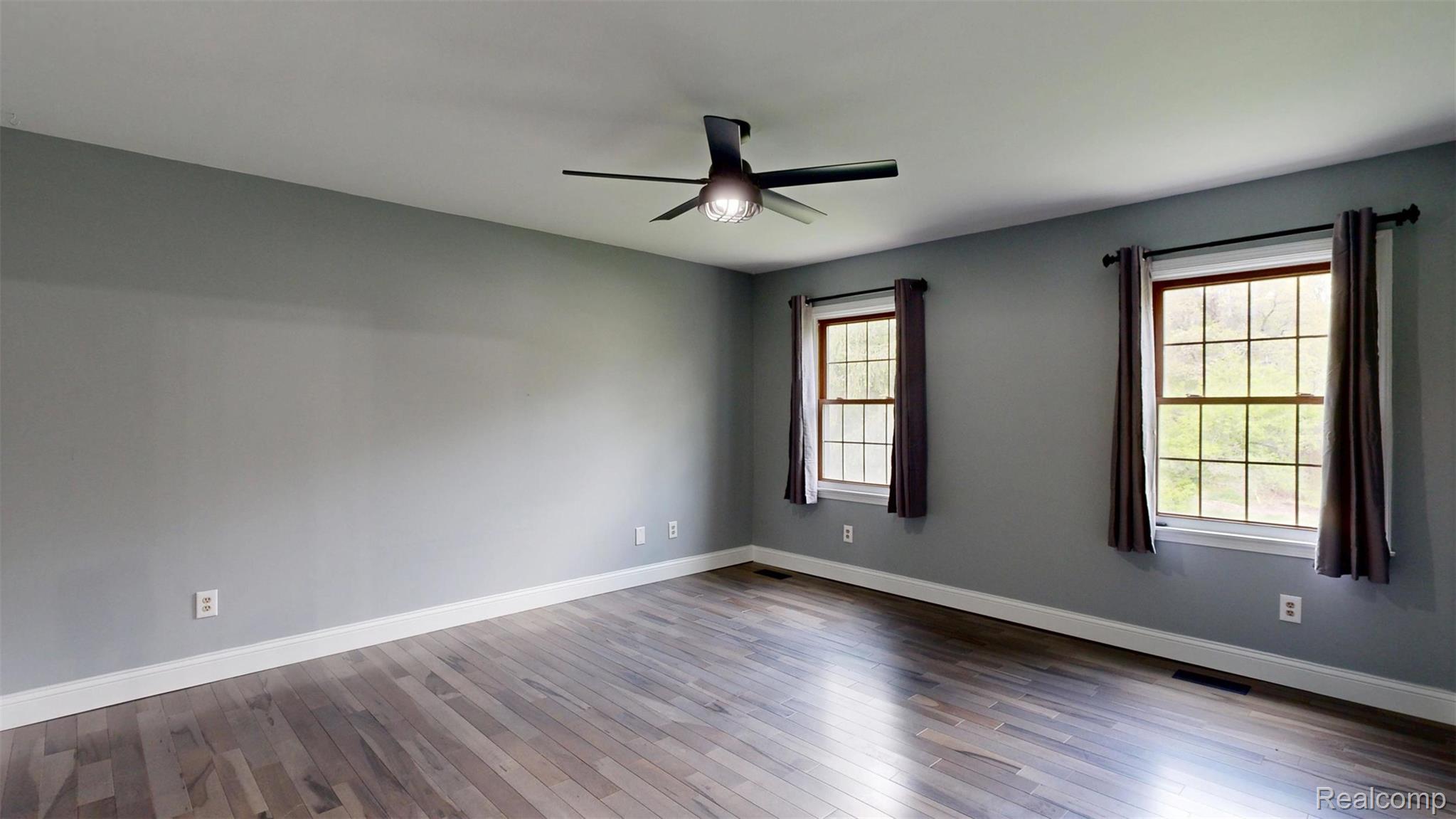 10300 Clark Road Davisburg, MI 48350 - Photo 17 of 39 Empty room with ceiling fan and dark wood-style floors