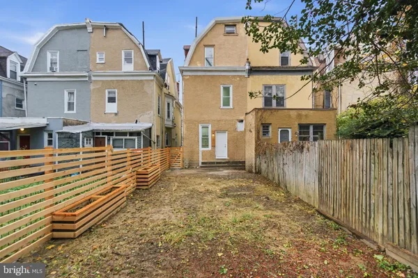 a view of a yard with plants and wooden fence