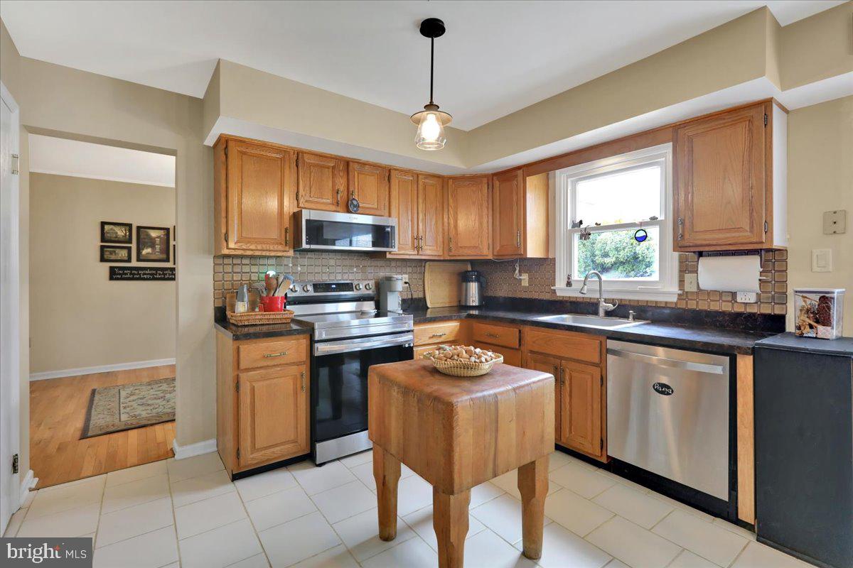 1839 Shellbark Drive Reading, PA 19608 - Photo 9 of 32 a kitchen with stainless steel appliances granite countertop a sink a stove a refrigerator cabinets and a window