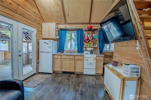 a kitchen that has a lot of white cabinets and stainless steel appliances