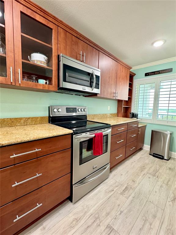 4620 Bay Boulevard, Unit 1145 Port Richey, FL 34668 - Photo 11 of 47 a kitchen with stainless steel appliances a stove microwave and cabinets
