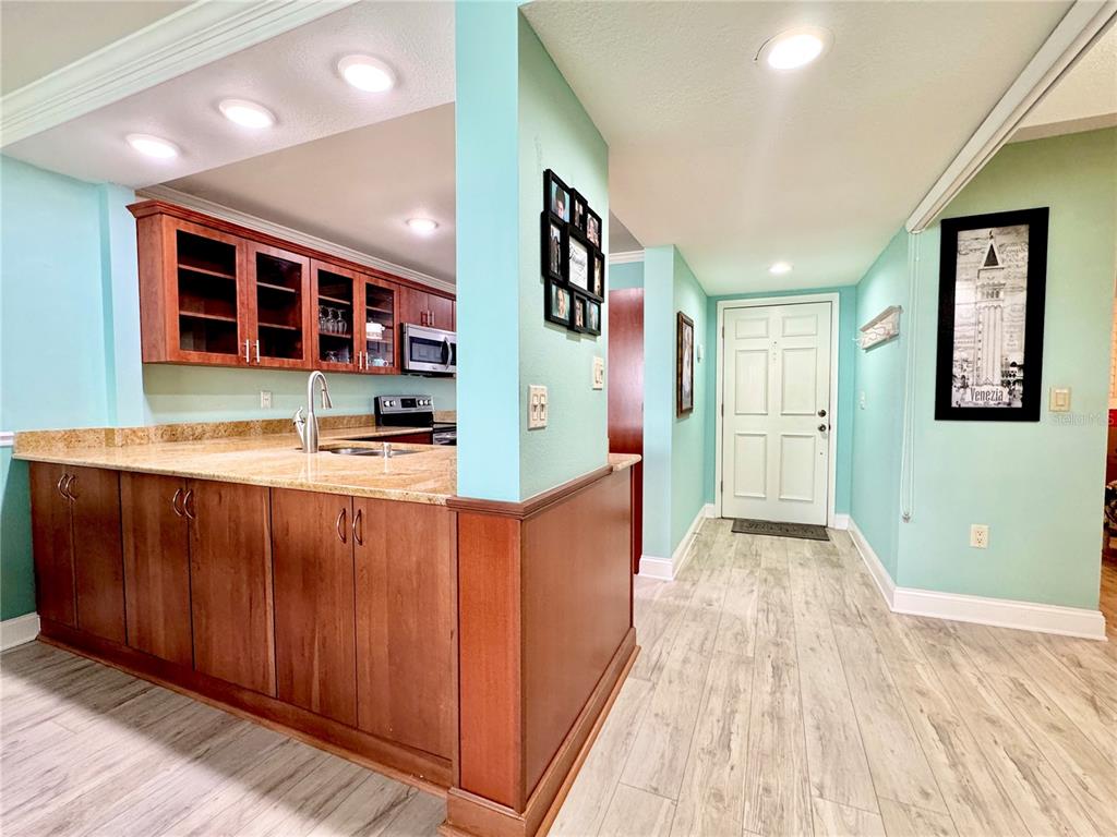 4620 Bay Boulevard, Unit 1145 Port Richey, FL 34668 - Photo 20 of 47 a hallway with stainless steel appliances granite countertop a refrigerator and a wooden cabinets
