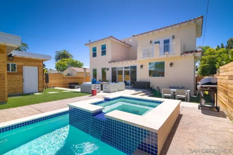 a view of a house with backyard swimming pool and sitting area