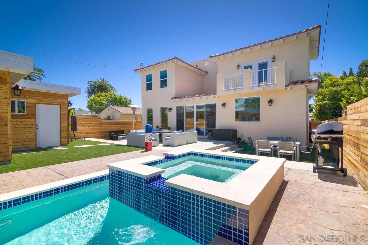 a view of a house with backyard swimming pool and sitting area