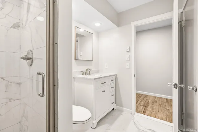 a bathroom with a sink a toilet a shower and a mirror