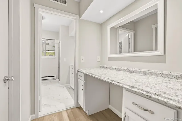 a bathroom with a granite countertop sink and a mirror