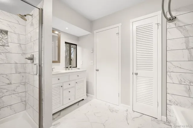 a bathroom with a double vanity sink a mirror and a shower
