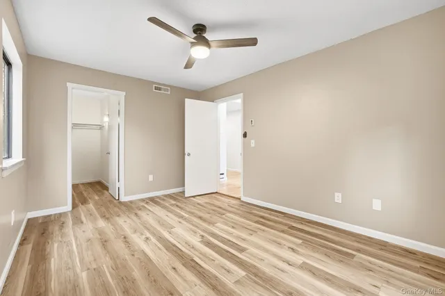 a view of room with wooden floor and ceiling fan