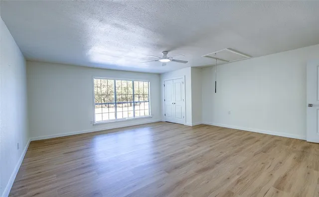 an empty room with wooden floor and windows