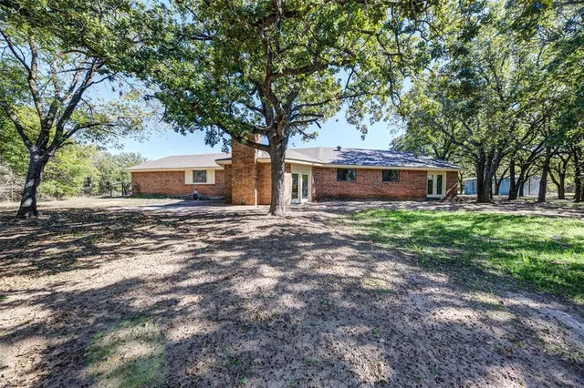 a view of a house with backyard and tree