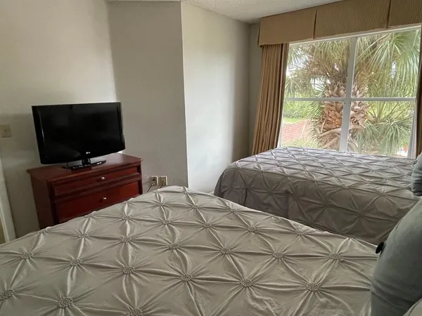 a bedroom with a bed and a flat screen tv