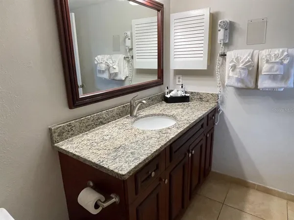 a bathroom with a granite countertop sink and a mirror