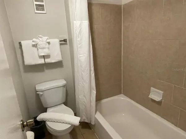 a white toilet sitting next to a bath tub
