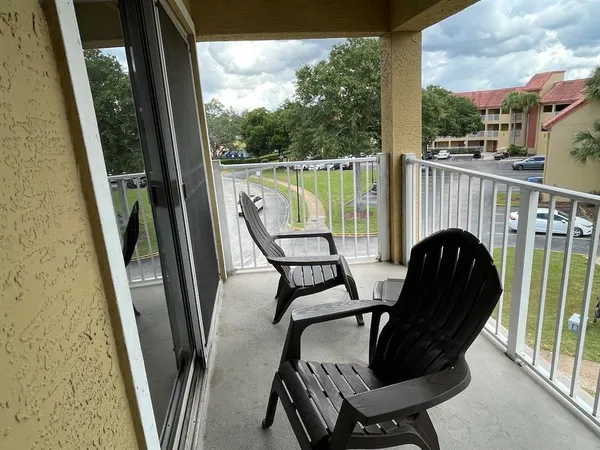 a view of a balcony with furniture and floor to ceiling window