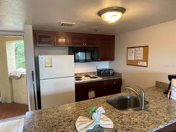 a kitchen with a refrigerator and a stove top oven