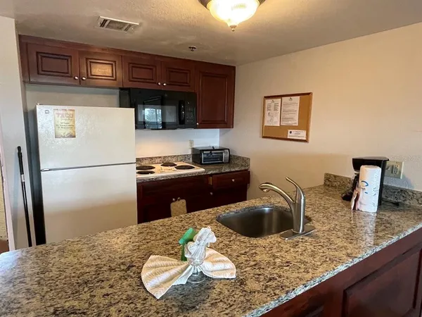 a kitchen with a sink a refrigerator and cabinets