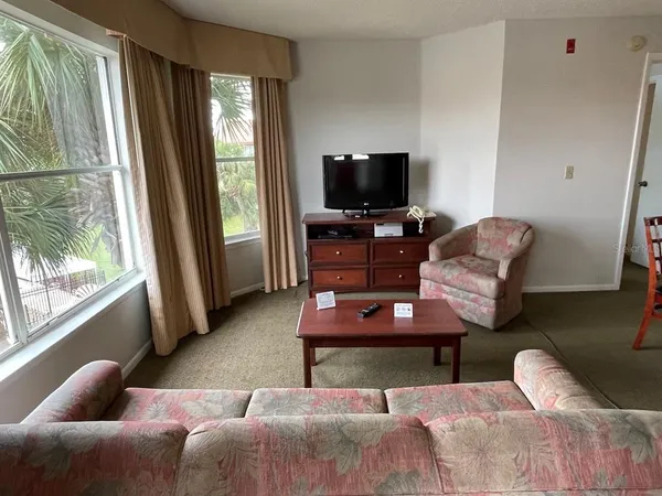 a living room with furniture a flat screen tv and a large window