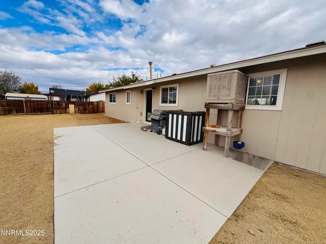 a backyard of a house with table and chairs