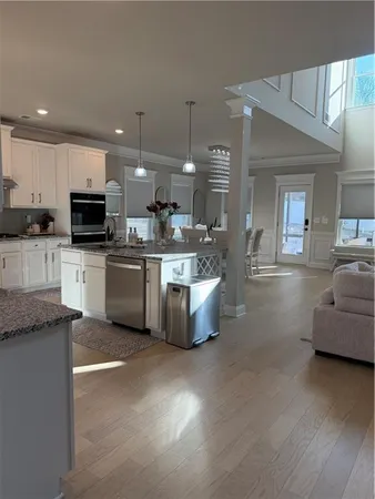 a living room with furniture and a dining table with wooden floor