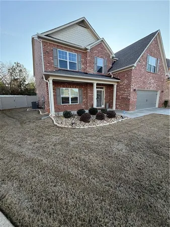 a front view of a house with a yard and a garage