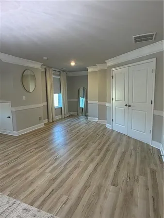 a view of a patio with table and chairs potted plants and floor to ceiling window