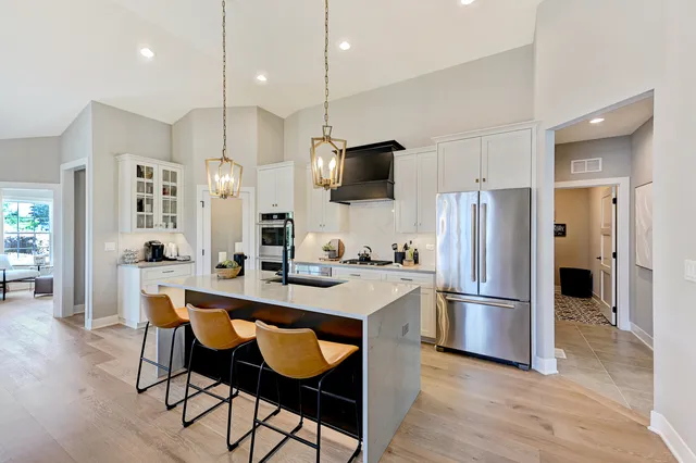 a kitchen with a refrigerator a table and chairs in it