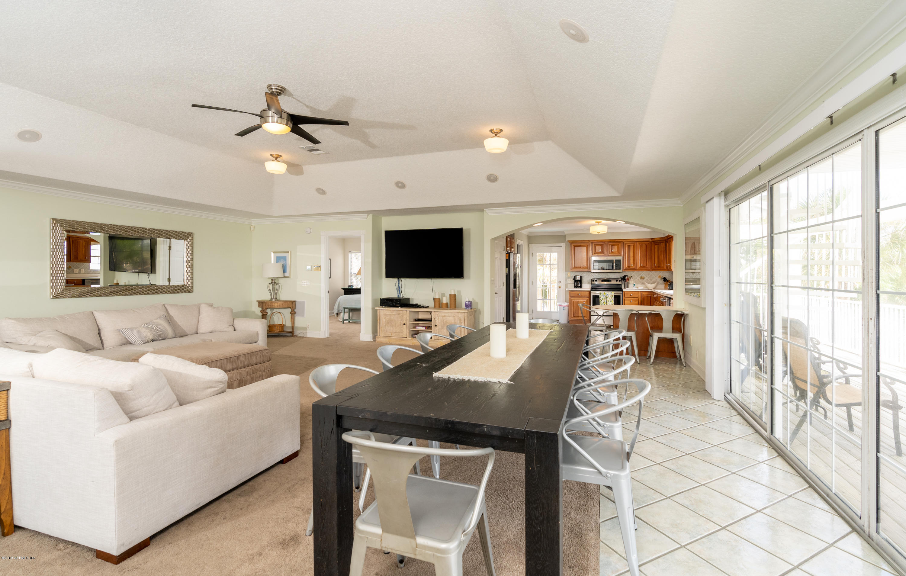 4 3rd Street St. Augustine, FL 32080 - Photo 19 of 47 a living room with furniture a flat screen tv and a floor to ceiling window
