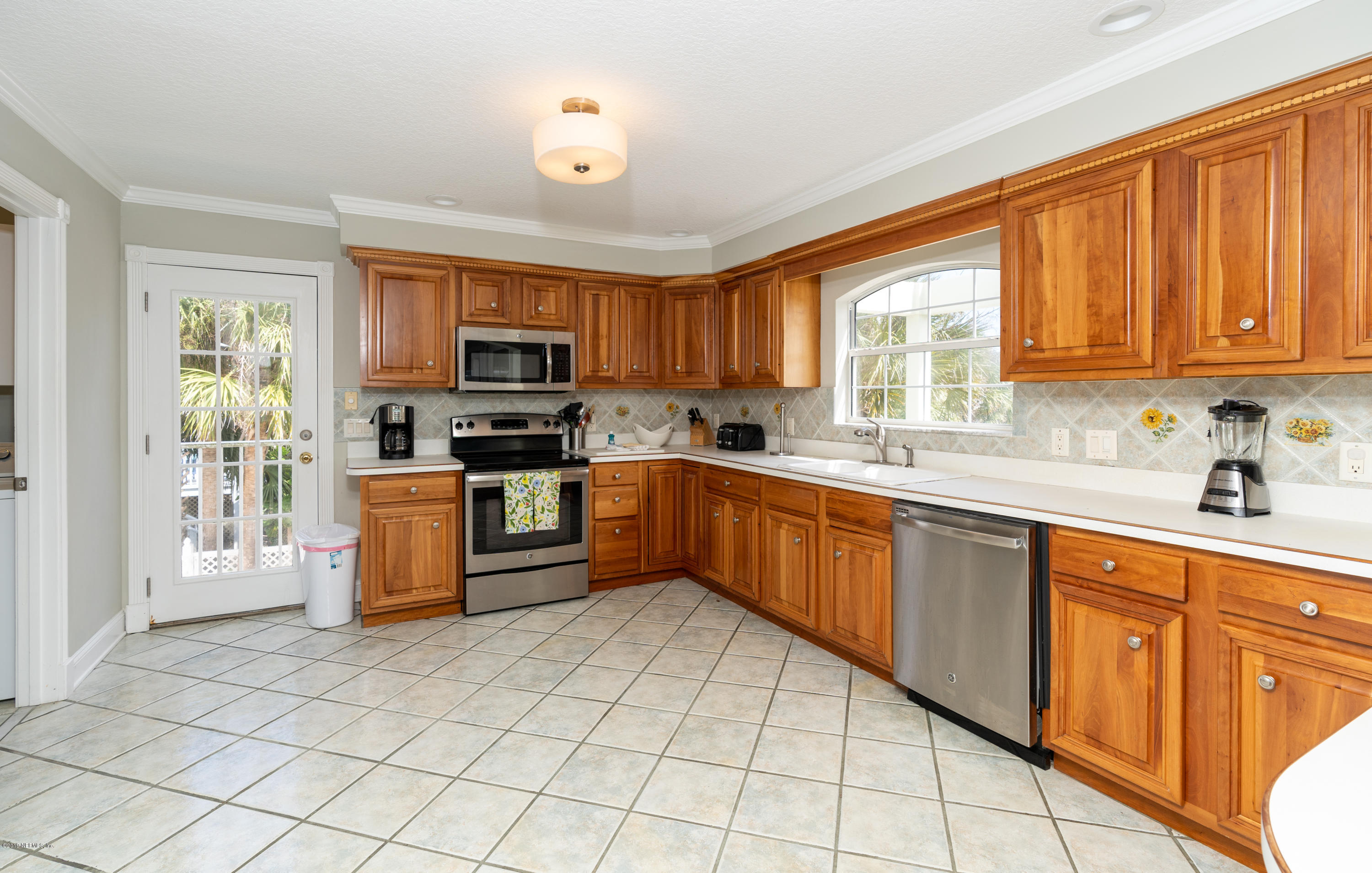 4 3rd Street St. Augustine, FL 32080 - Photo 22 of 47 a kitchen with stainless steel appliances granite countertop a stove top oven a sink dishwasher a dining table and chairs with wooden floor