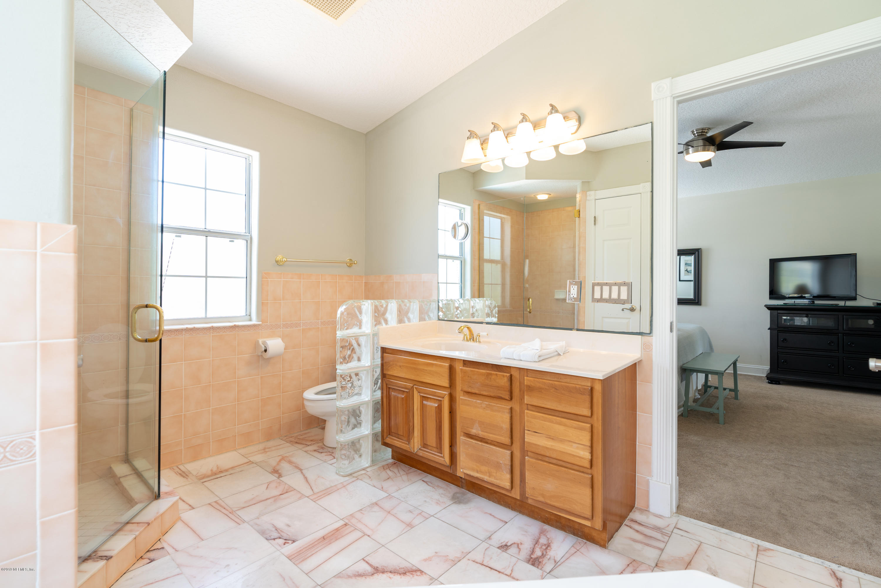 4 3rd Street St. Augustine, FL 32080 - Photo 32 of 47 a spacious bathroom with a granite countertop sink a mirror and a toilet