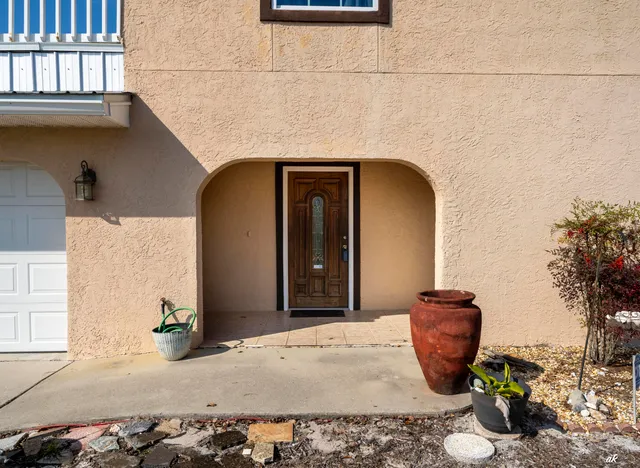 a view of a livingroom with a fireplace a chandelier fan and windows