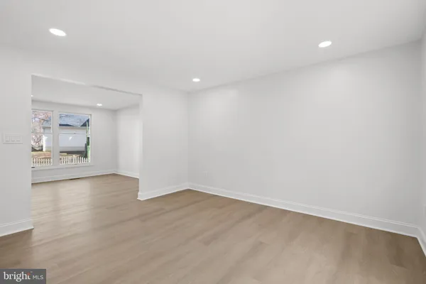 an empty room with window and wooden floor