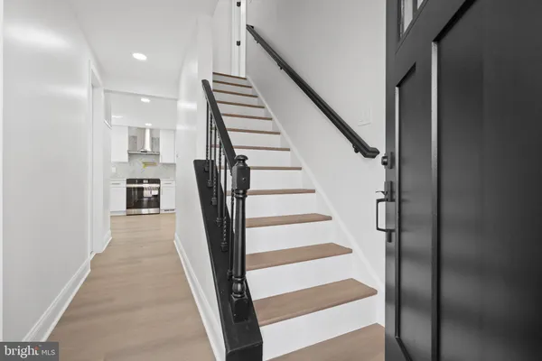 a view of an empty room with wooden floor and windows