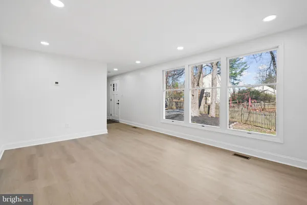 a kitchen with stainless steel appliances granite countertop a sink a stove a refrigerator and white cabinets