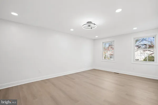 a spacious bathroom with a granite countertop sink a mirror and a bathtub