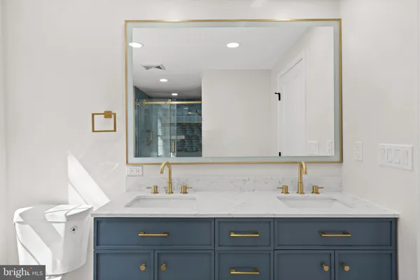 a bathroom with a sink a toilet and a mirror