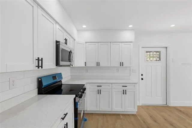 a kitchen with stainless steel appliances cabinets and wooden floor