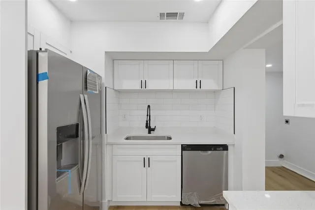 a kitchen with appliances cabinets and a refrigerator