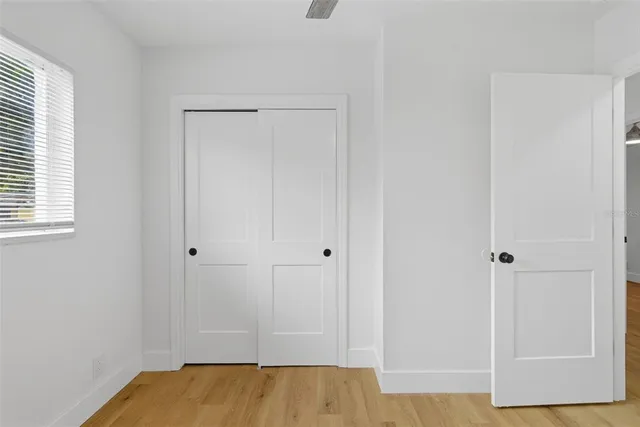 an empty room with a window and ceiling fan