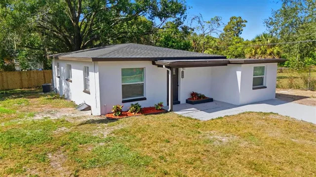 a view of a house with backyard and sitting area