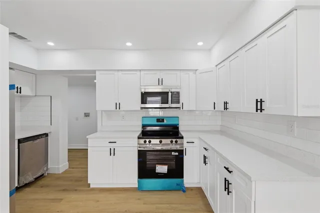 a kitchen with stainless steel appliances a stove a sink and a refrigerator