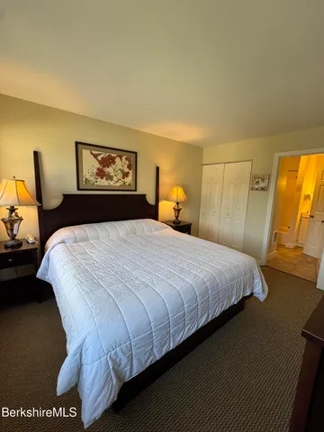 a kitchen with a stove a refrigerator a sink and white cabinets with wooden floor