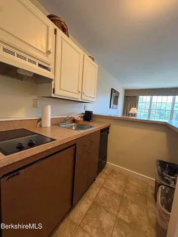 a kitchen with a refrigerator and a stove top oven