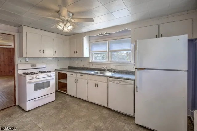 a kitchen with granite countertop cabinets appliances a sink and a window
