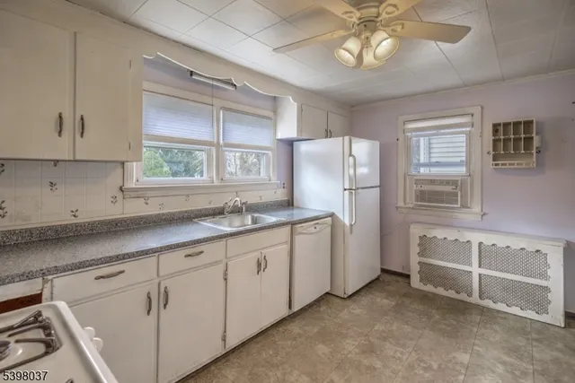 a kitchen with white cabinets and window