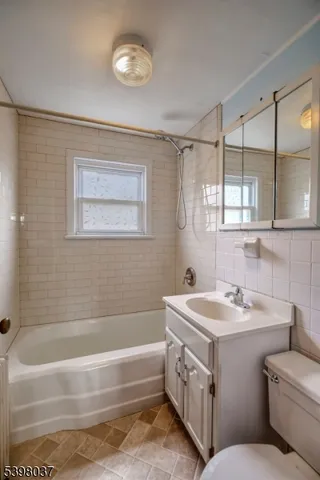a bathroom with a tub a sink and a mirror